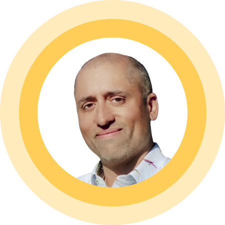 Bald man smiling, wearing a white shirt, inside a yellow circular frame on a white background.