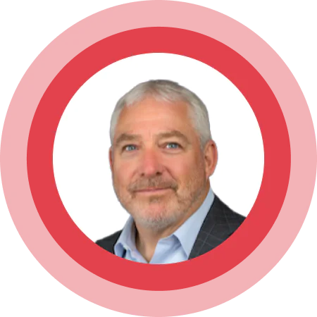 Portrait of a white-haired man with a beard in a red circular frame.
