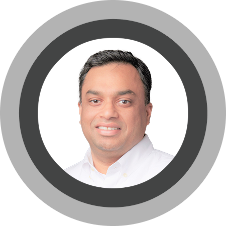 Smiling man with short black hair wearing a white shirt against a white background.