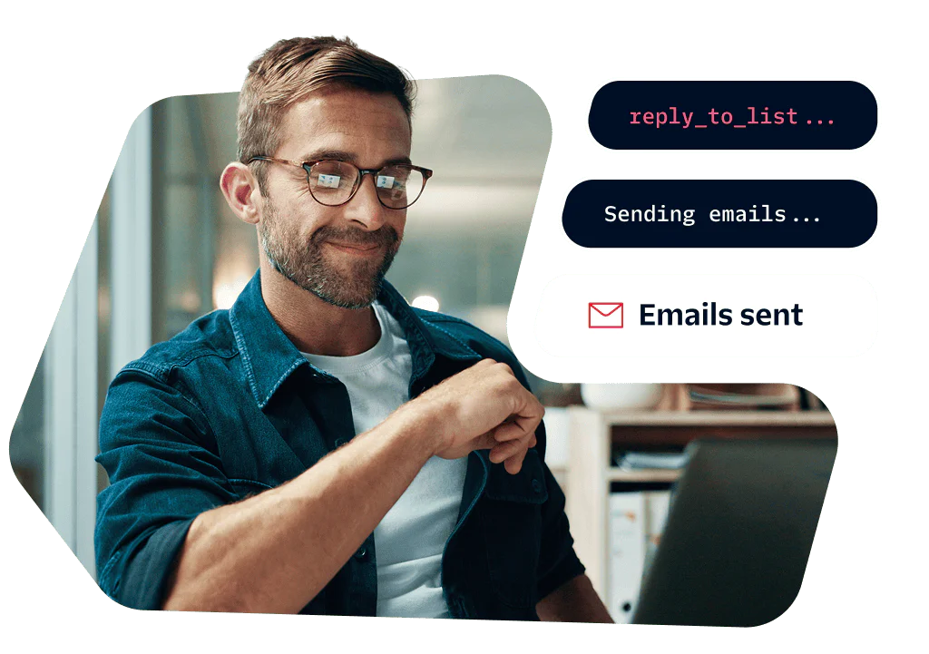 Man wearing glasses using a computer to send emails in an office.