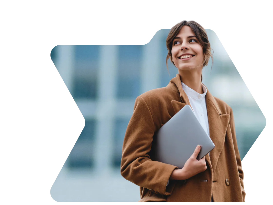 Woman in brown coat smiling and holding a laptop with a birthday discount notification from OWLCLOTHES