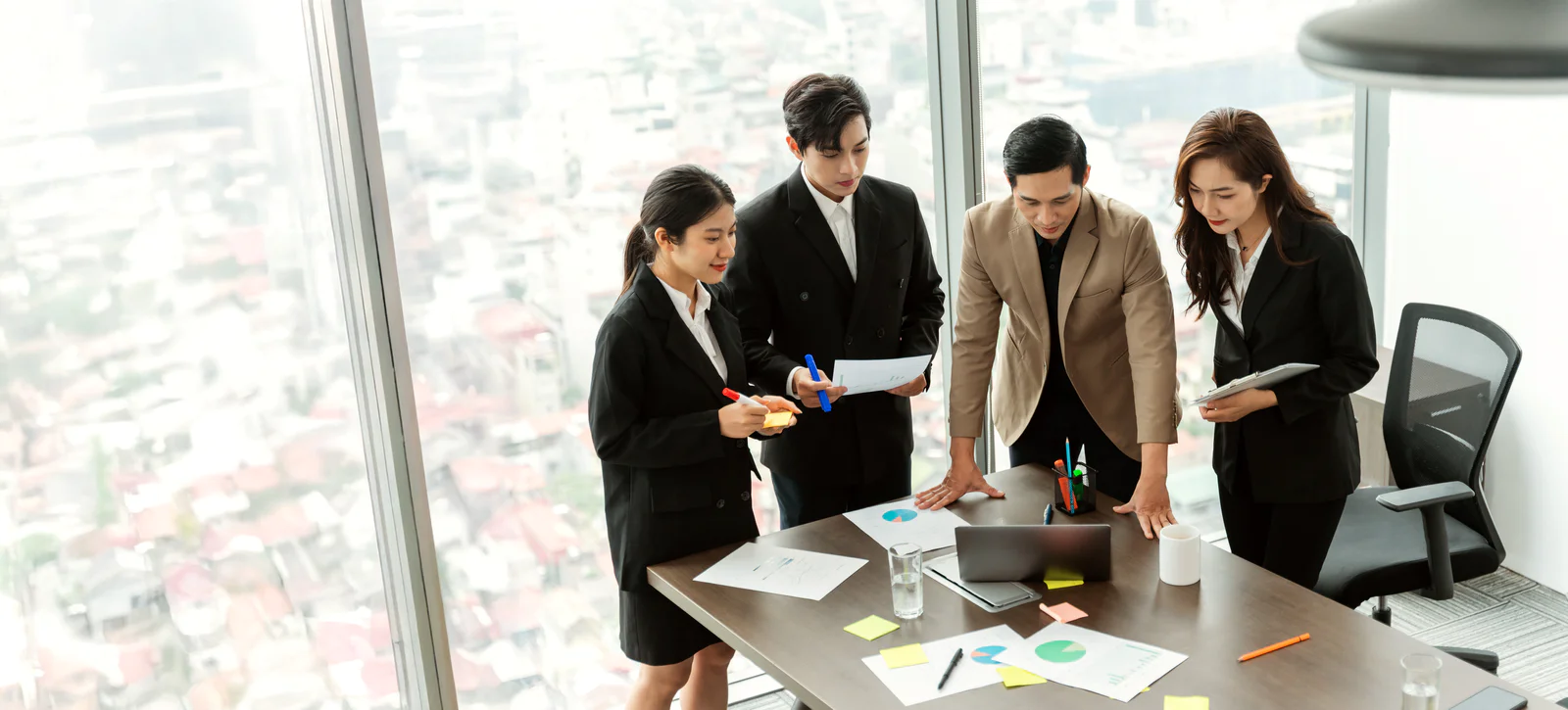 Colleagues smiling and shaking hands in a modern office environment.