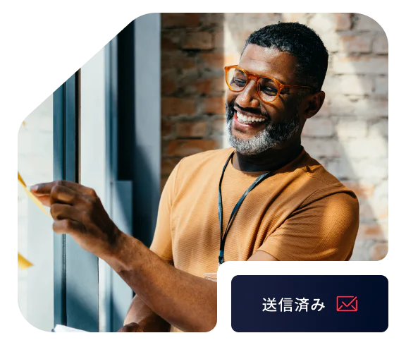 Smiling man with glasses sticking a note on a window