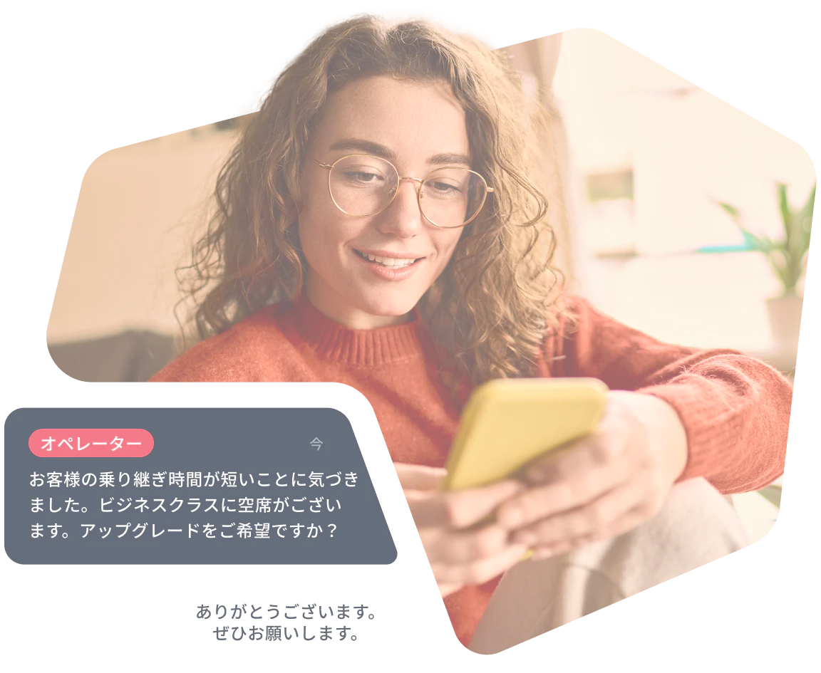Woman smiles while reading a phone, screen shows a chat offering a business class seat upgrade.