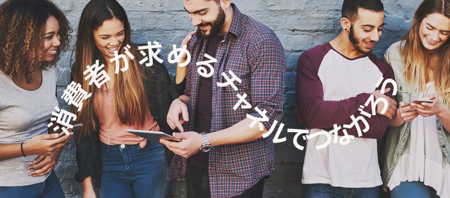 Diverse group of friends looking at mobile devices and tablet, text above says Meet consumers on their preferred channels.