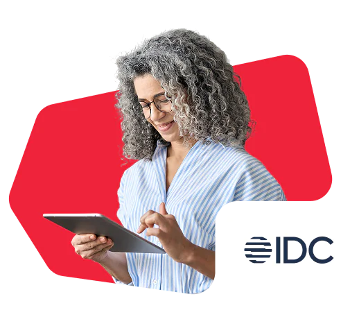 Woman with curly gray hair using a tablet, IDC logo in the corner.