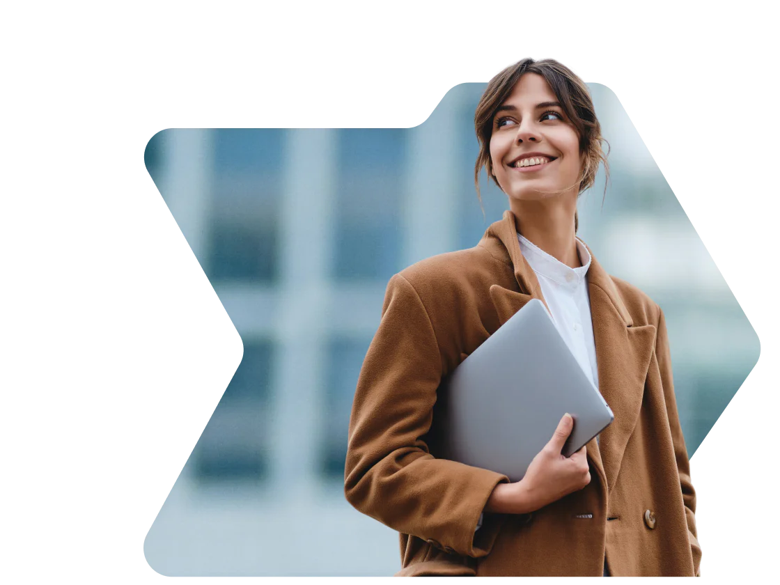 Woman in brown coat smiling and holding a laptop with a birthday discount notification from OWLCLOTHES