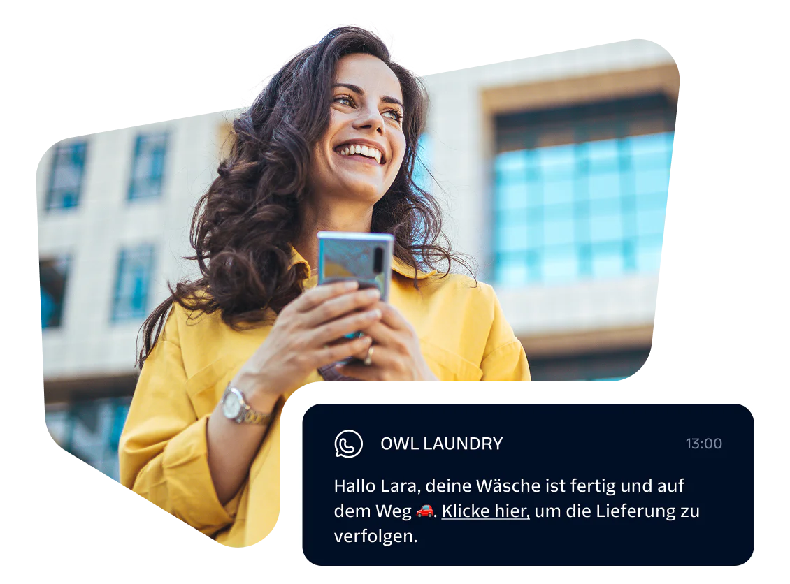 Smiling woman holding phone with a message notification from Owl Laundry.