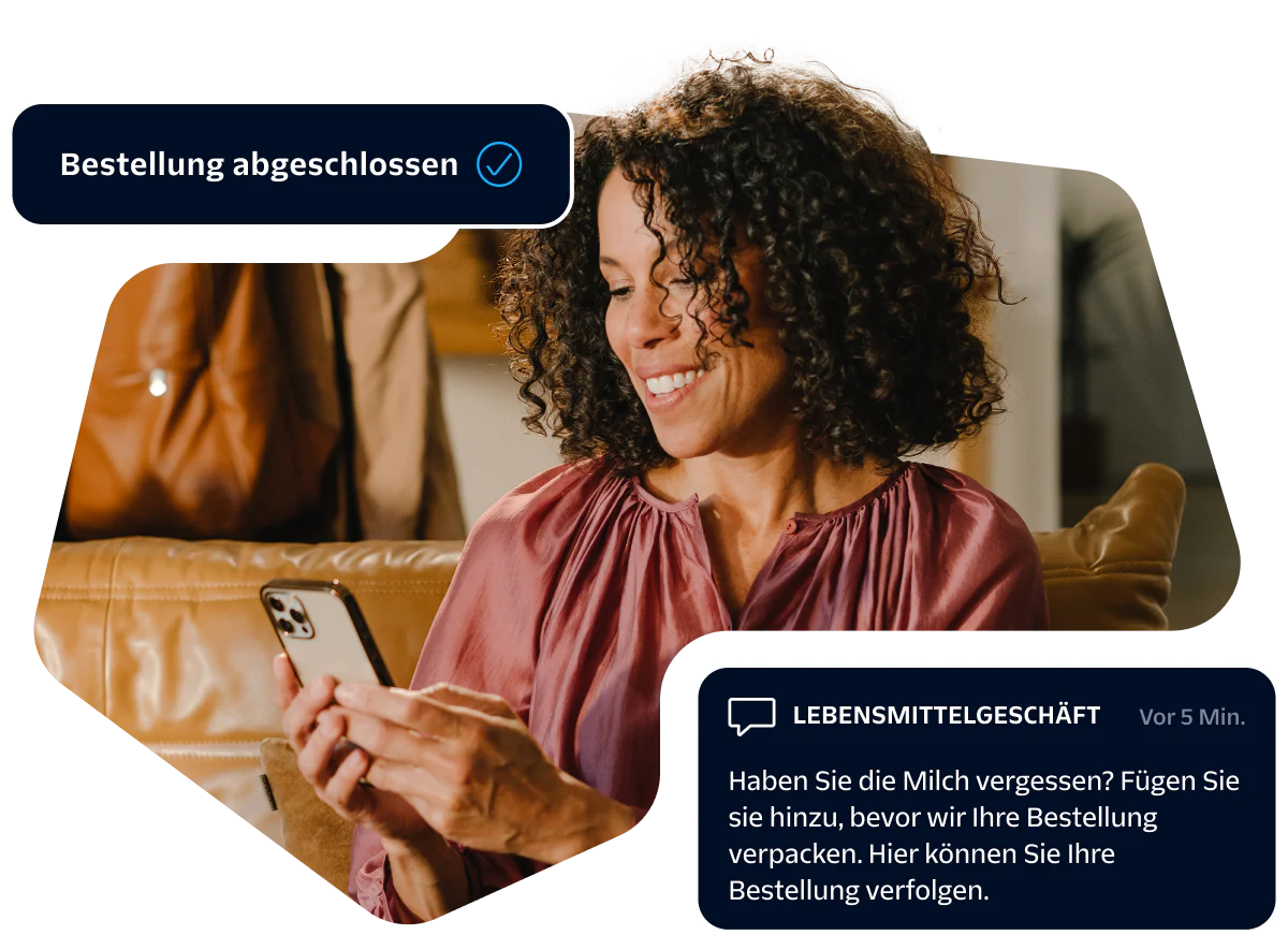 Woman smiling at her smartphone while receiving an online grocery order confirmation message.
