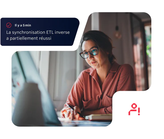 Woman wearing glasses and pink shirt working on a laptop with an ETL sync notification.