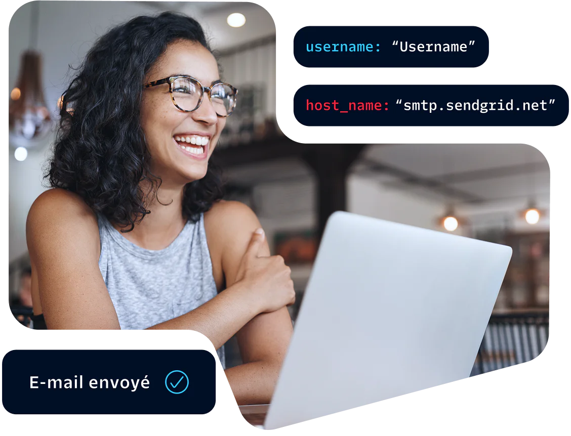 Woman wearing glasses smiling and working on a laptop with an email sent notification displayed.