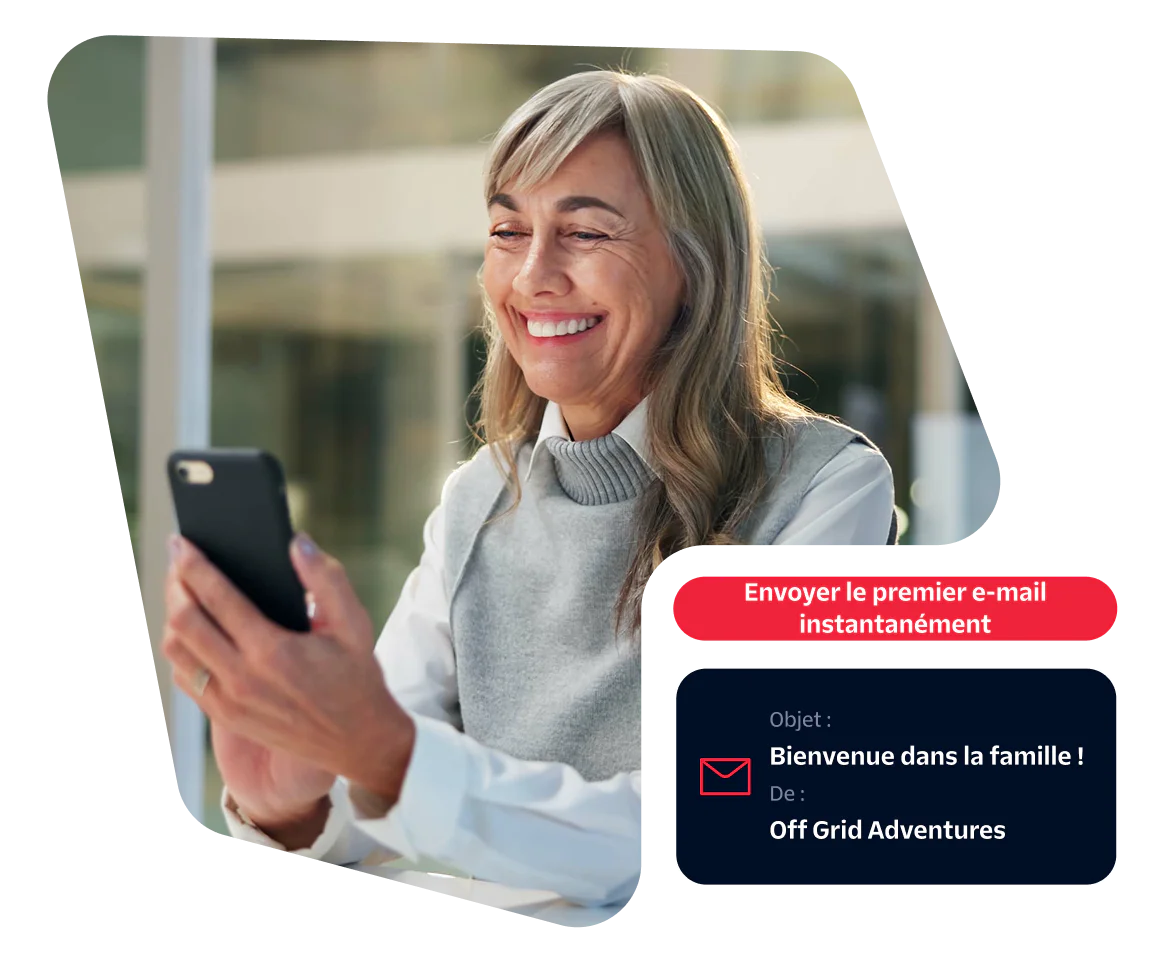 Smiling older woman using a smartphone with a pop-up message prompt to send the first email instantly.