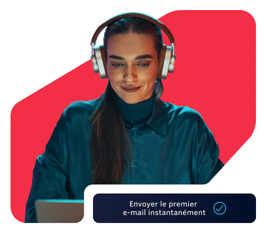 Woman wearing headphones working on her laptop Woman in headphones using a laptop with a prompt to send the first email instantly