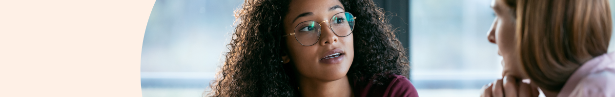 Woman with glasses having a conversation with another woman