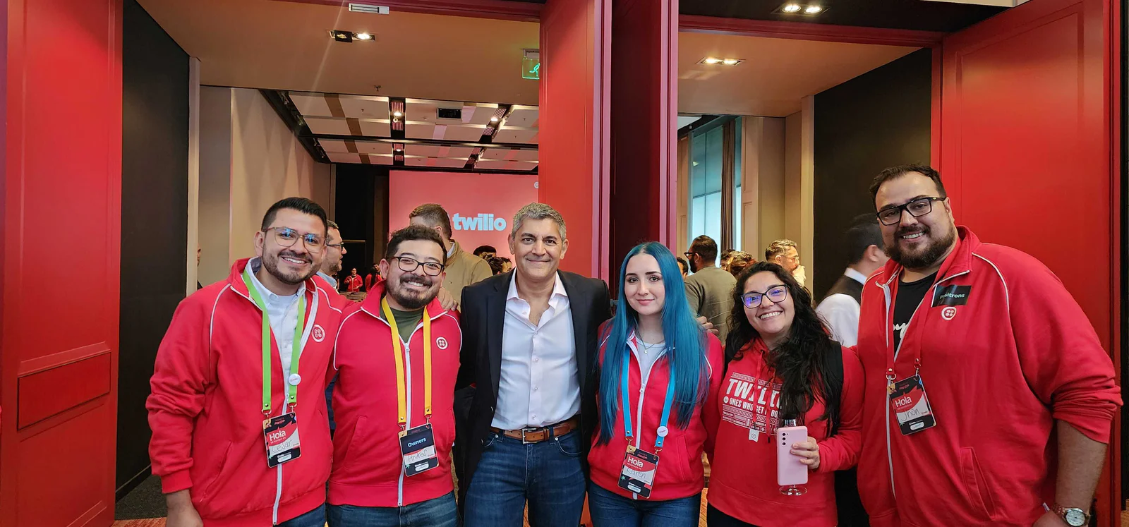 Group of People at Twilio Event Group of six people standing together at a Twilio event, smiling at the camera.