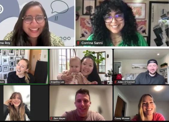 Nine people in a virtual meeting, including a baby, laughing and smiling.
