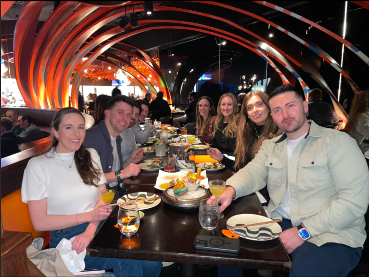 A group of people enjoying a meal at a restaurant with colorful decor and arched designs.