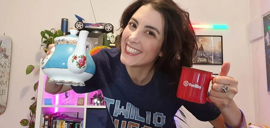 Mish Smiling with Teapot and Mug in Hand Selfie of Mish with a pot of tea and a red Twilio mug