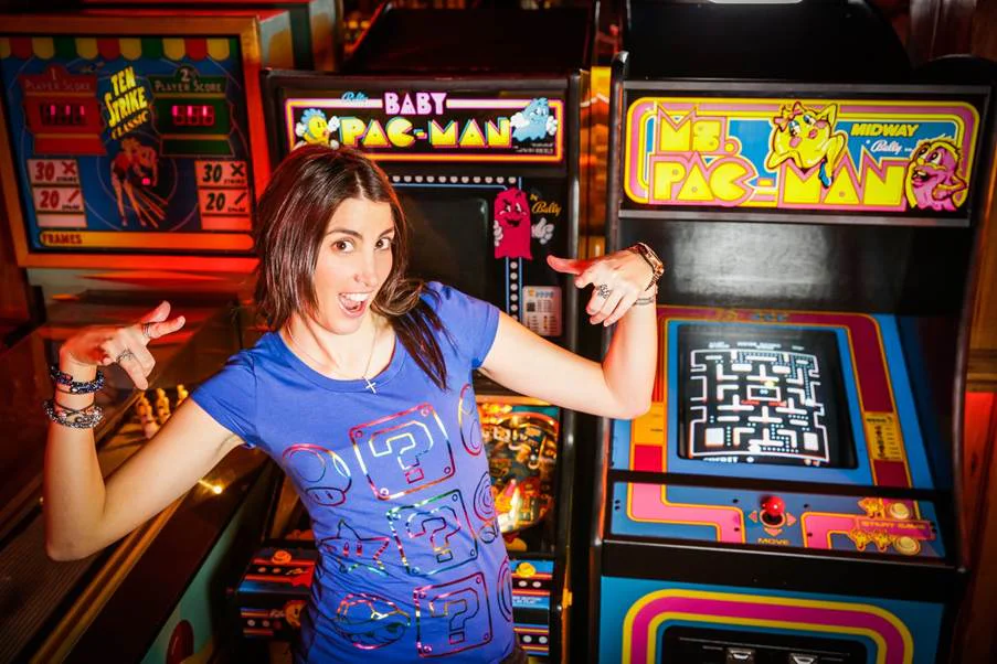 Mish Posing with Classic Pac-Man and Baby Pac-Man Arcade Games Mish in front of arcade machines wearing a Super Mario shirt