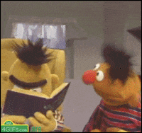 GIF image of Sesame Street's Ernie laughing that pans to Burt lowering a book and staring dead-pan into the camera