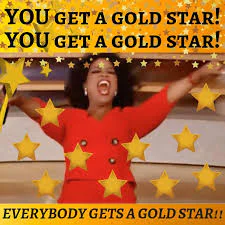 Oprah Winfrey in a red suit surrounded by gold stars. She is shouting excitedly with her arms outstretched: "You get a gold star! You get a gold star! Everyone gets a gold star!!"