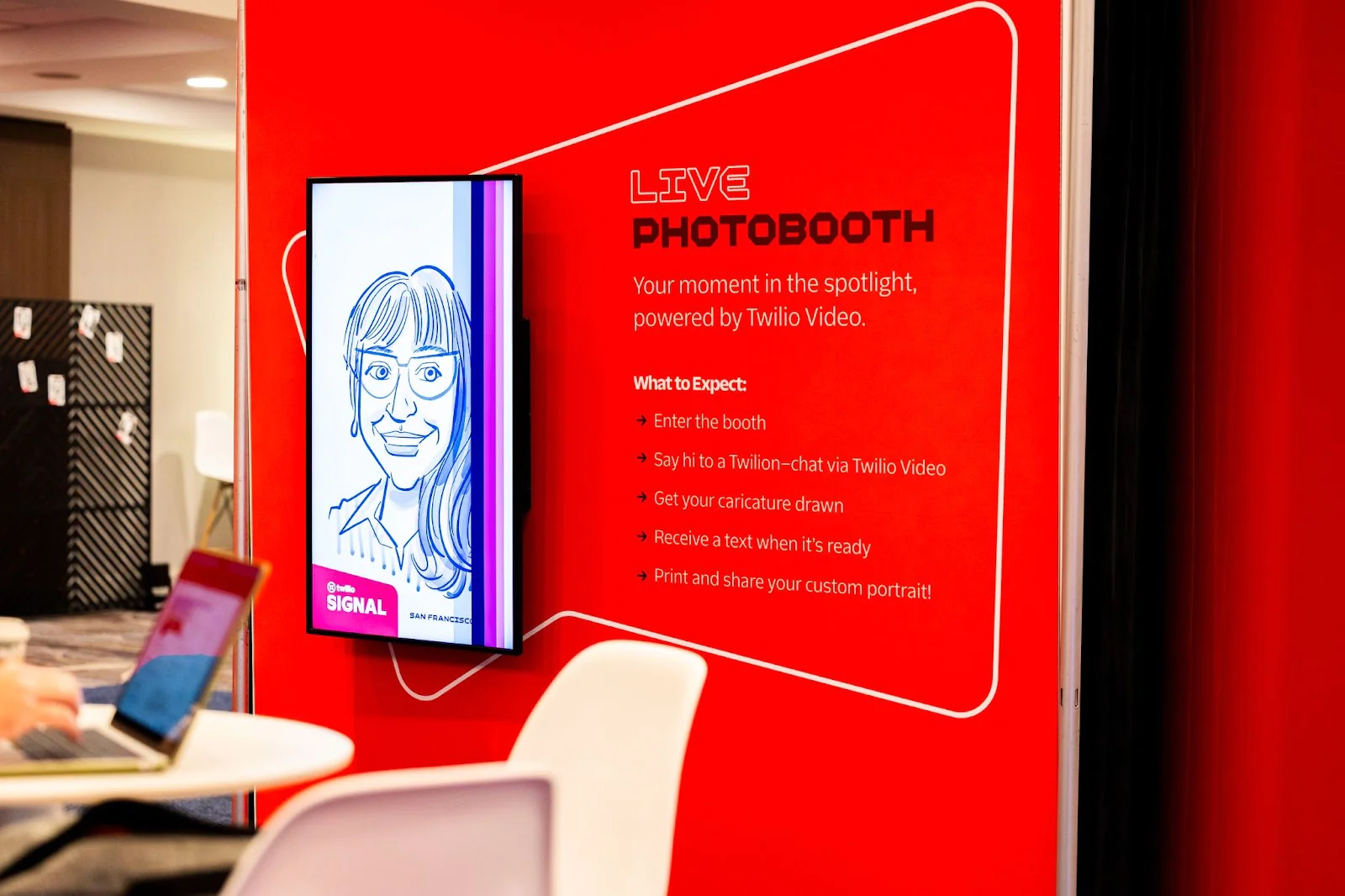 Red booth with LIVE PHOTOBOOTH sign and illustration, offering custom portraits at Twilio Video event. Red booth with LIVE PHOTOBOOTH sign and illustration, offering custom portraits at Twilio Video event.