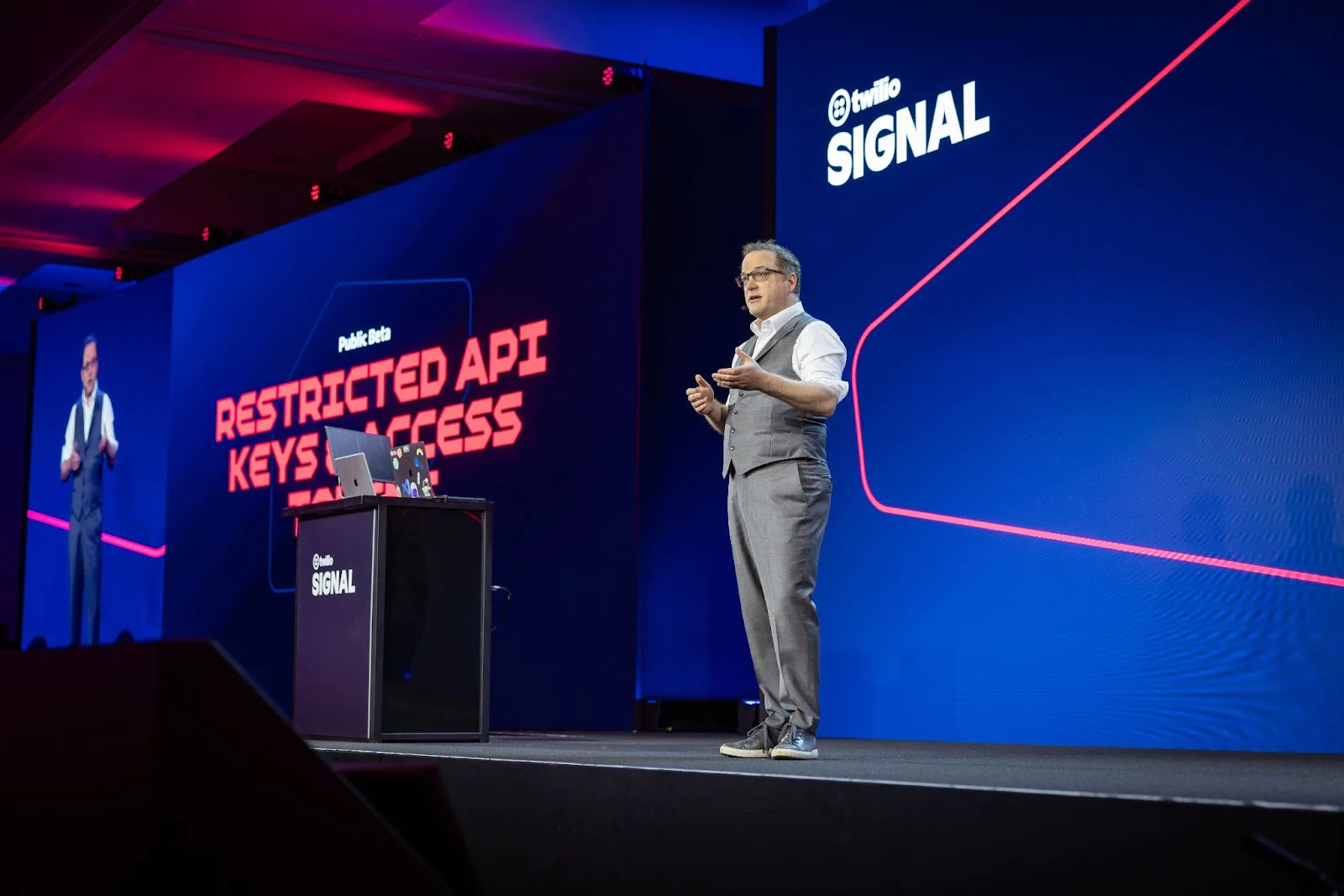 Man standing on stage giving a presentation at Twilio Signal conference with Restricted API Keys Access on screen. Man standing on stage giving a presentation at Twilio Signal conference with Restricted API Keys Access on screen.
