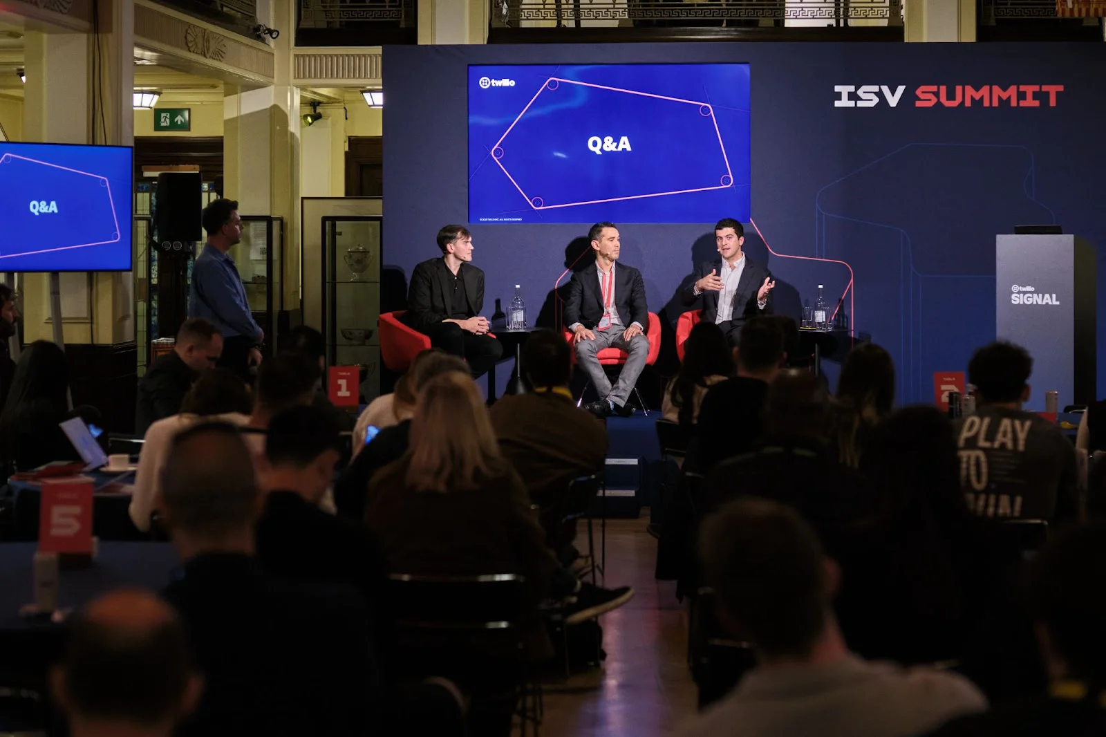 Three speakers on stage during a Q&A session at the ISV Summit, with an audience listening.