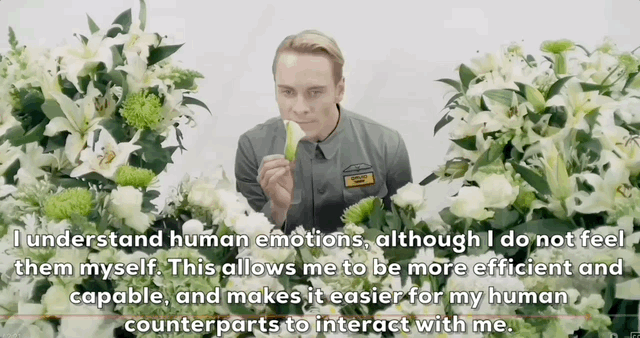 An android in uniform eating fruit while surrounded by white and green flowers, with a text overlay about human emotions.