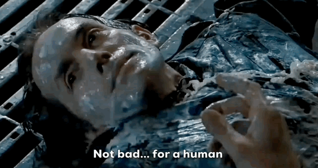 Injured man lying on the ground covered in a blue liquid with the text Not bad... for a human.
