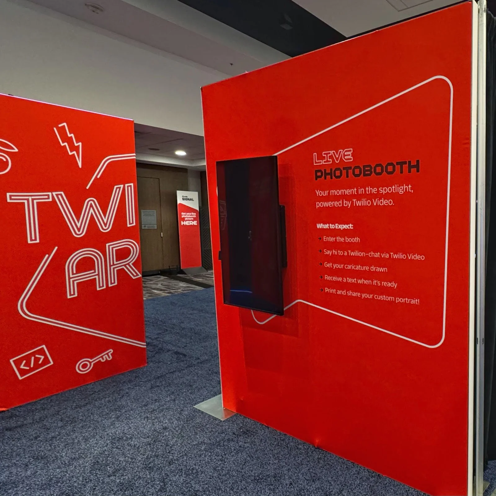 Red booth with Twilio AR and Live Photobooth signage at a conference. Red booth with Twilio AR and Live Photobooth signage at a conference.