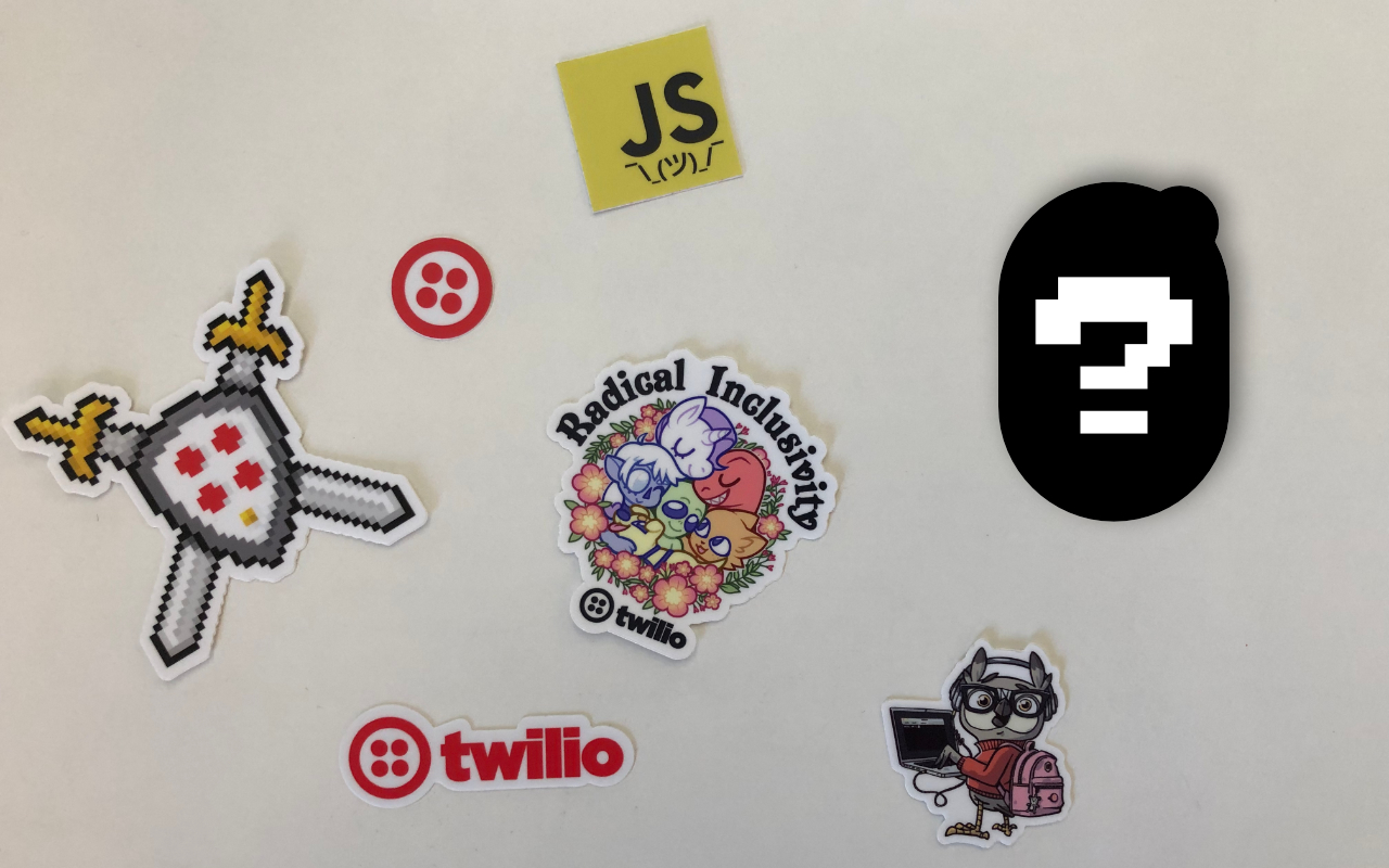 Photo of various Twilio stickers on a table with the outline of another sticker and a question mark on top of it