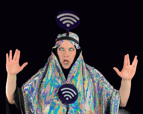Animated gif of a person wearing a holographic..snuggie? With wifi signs on the chest and head. They are making a weird face and vapor is floating up from the bottom of the viewport to the top.