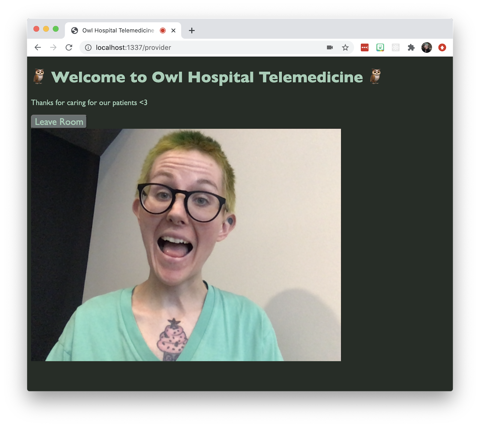 Screenshot of a Twilio Video app that says "Welcome to Owl Hospital Telemedicine." Small text says "Thanks for caring for our patients." There&#x27;s a button that says "Leave Room" and a non-binary person in the video chat, with green hair, making a silly face.