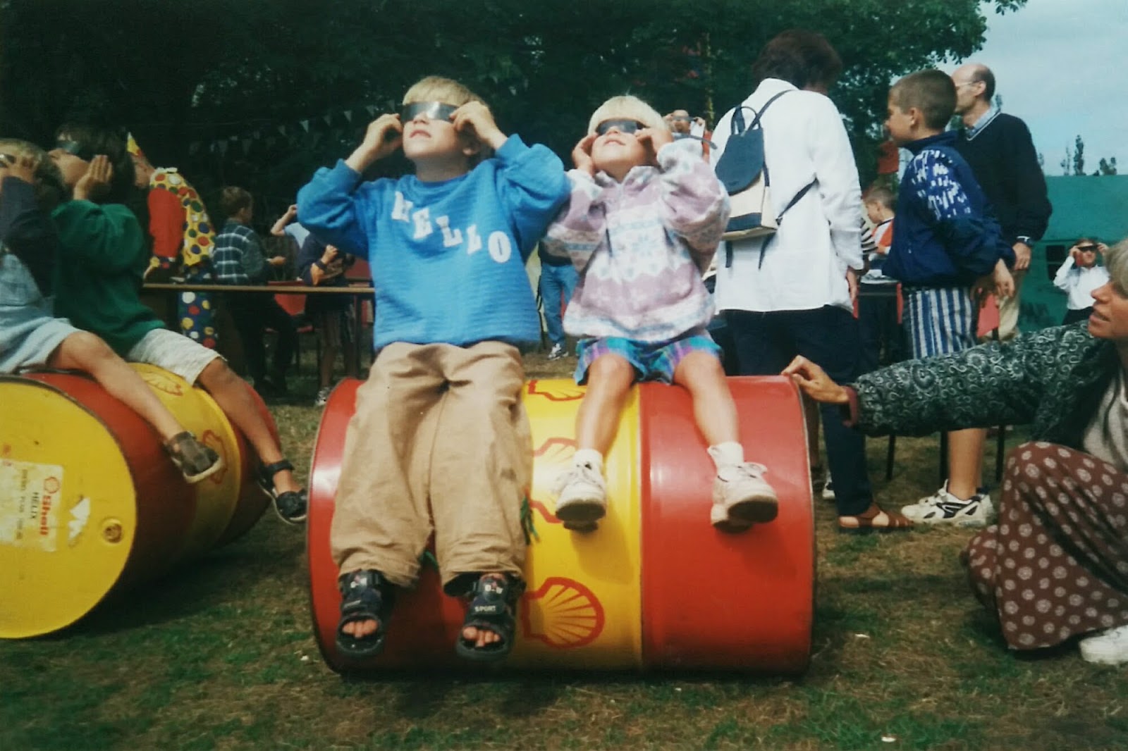 Niels&#x27; brother and Niels sitting on a barrel watching the eclipse through shades