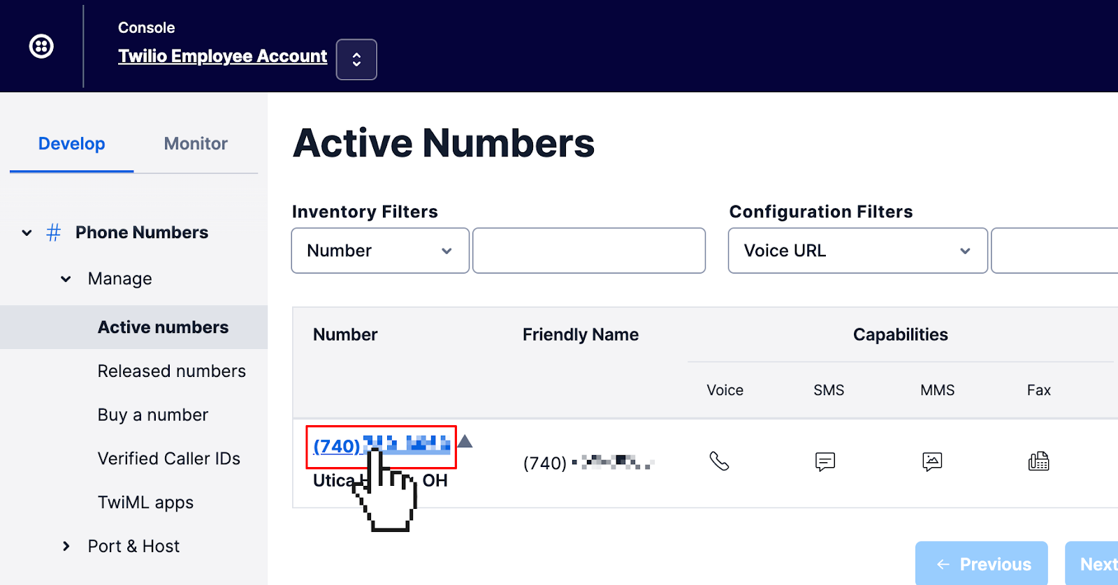 Twilio Console page listing active phone numbers in your Twilio account. Cursor is clicking on the single phone number in the list.