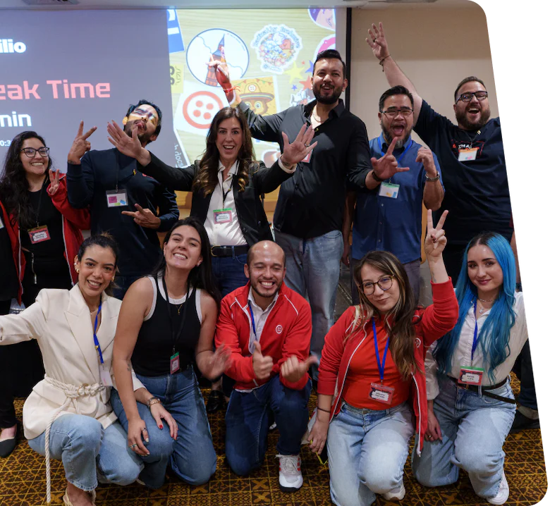 Group of people posing excitedly in front of a presentation screen during a break time event.