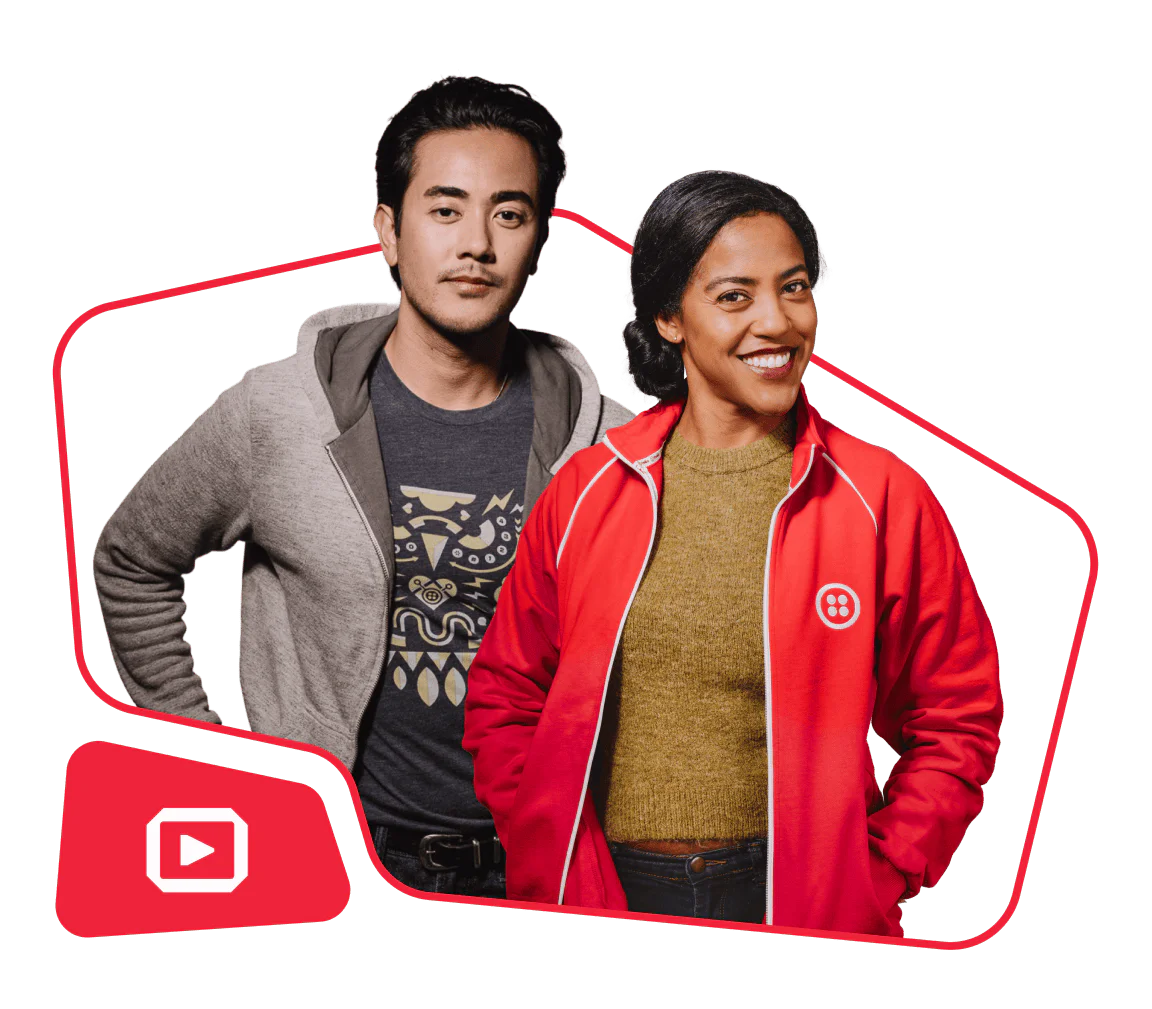 Man in a gray hoodie and woman in a red jacket with Twilio logo posing together