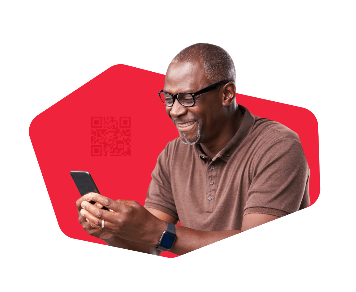 Man wearing glasses and a brown shirt smiling while looking at his smartphone.