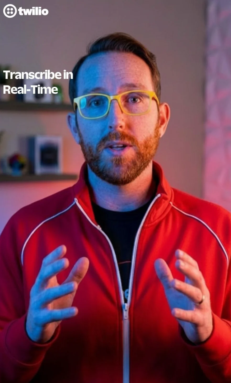Presenter in a red jacket with yellow glasses talking about real-time transcription with Twilio branding.