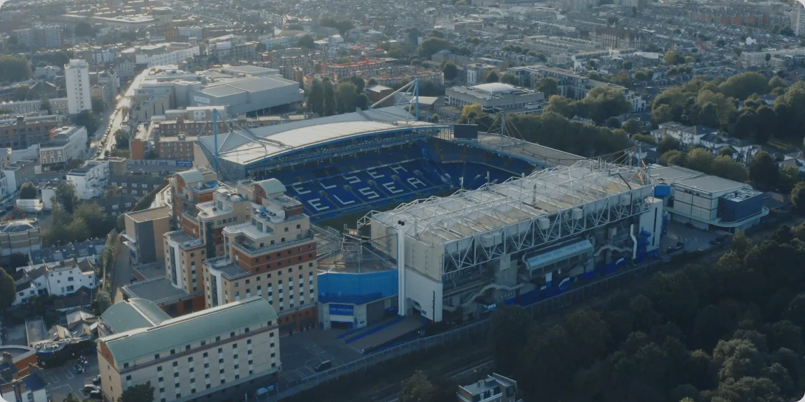 Aerial view of a football stadium named Chelsea with surrounding city buildings.