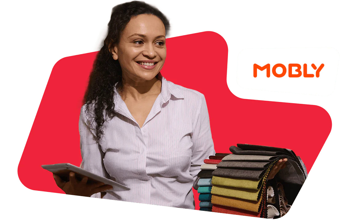Smiling woman holding fabric samples and a tablet with a Mobly logo backdrop