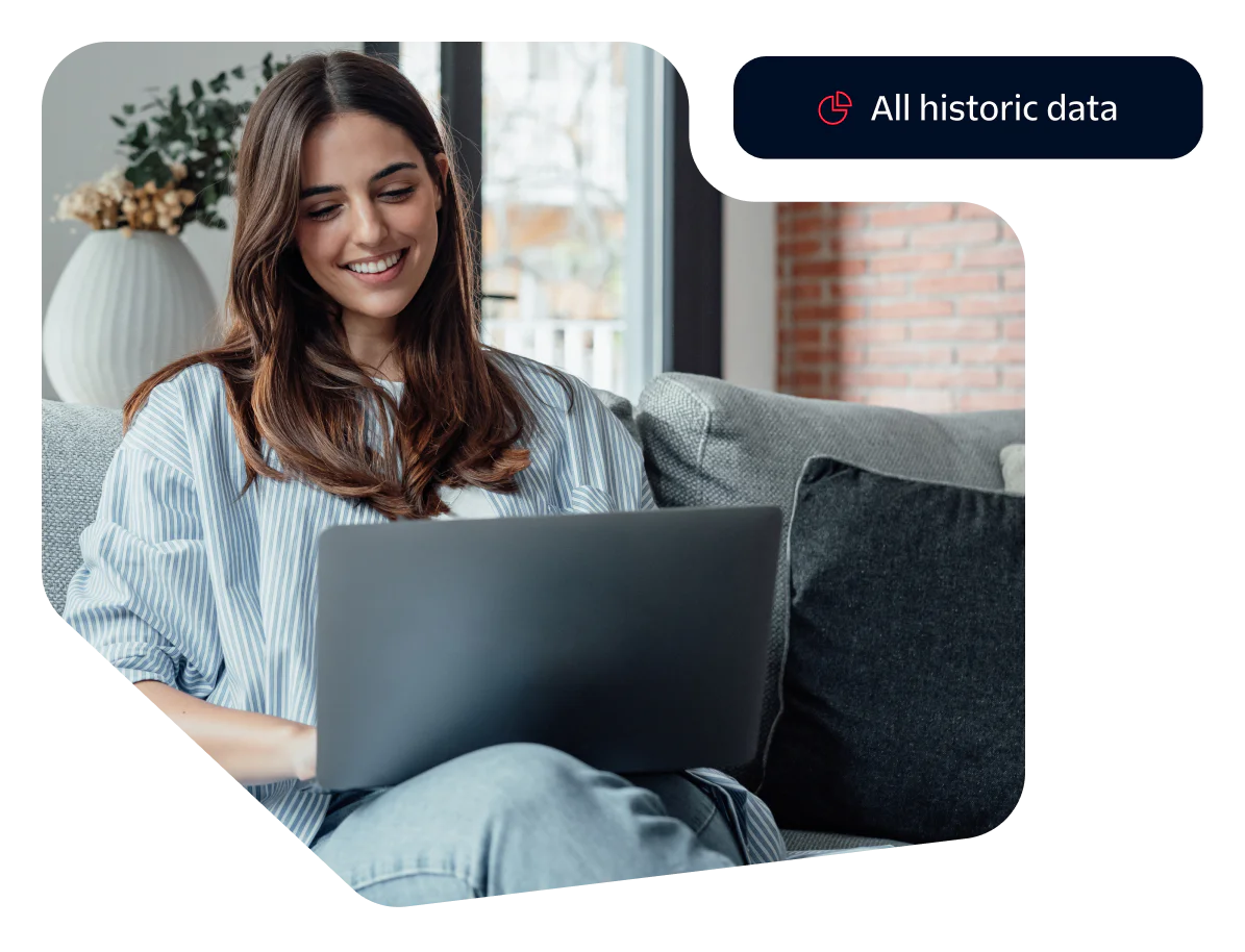 Smiling woman sitting on a couch using a laptop