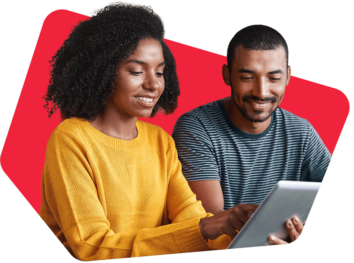 Two people smiling and looking at a tablet against a red background