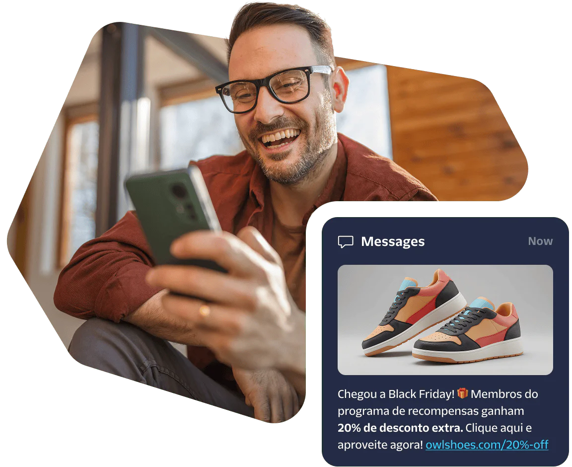 Smiling man looking at phone with a message about 20% discount on sneakers.