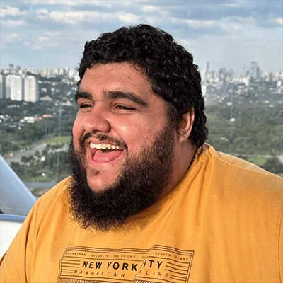 Bearded man in yellow shirt smiling with cityscape in the background