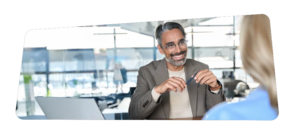 Professional Discussion at Modern Office Man in a beige blazer talking to a woman in an office setting.