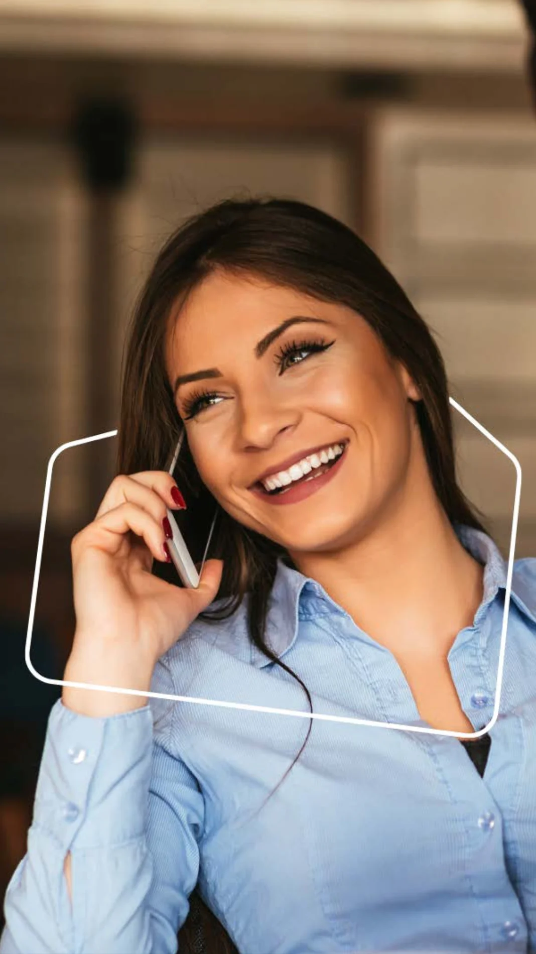 Woman with long hair smiling while on a phone call.
