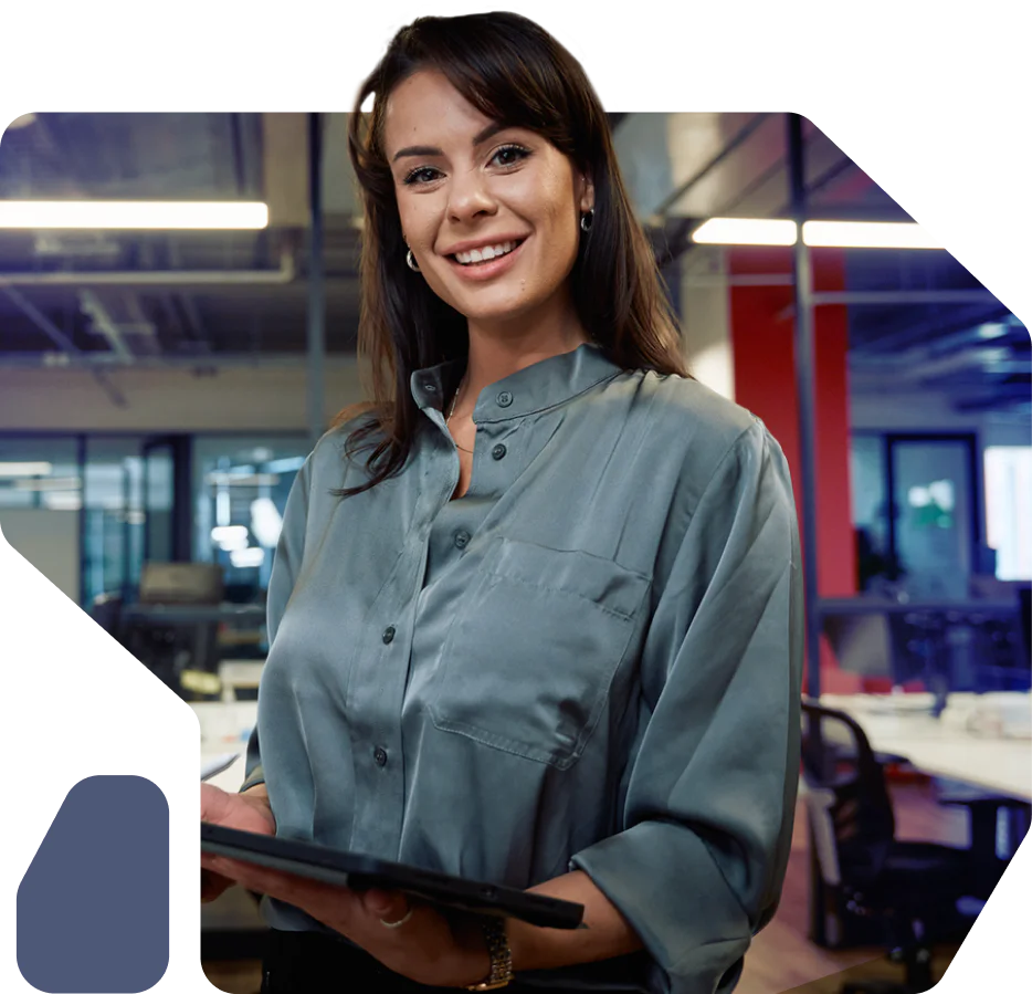 Professional woman smiling and holding a tablet in a modern office setting