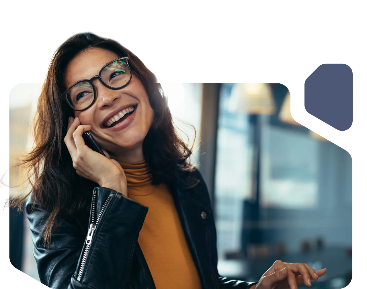 Woman with glasses laughing as she talks on the phone